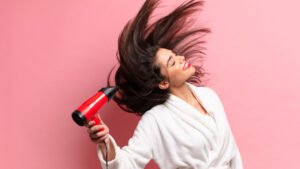 a girl drying her hair with hair dryer