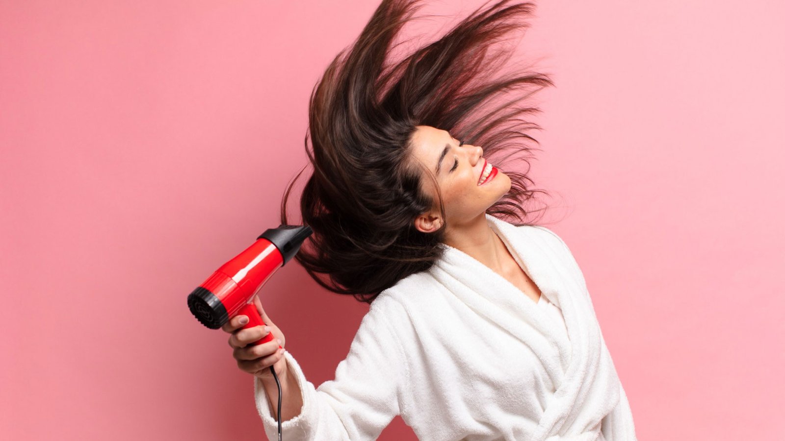 a girl drying her hair with hair dryer